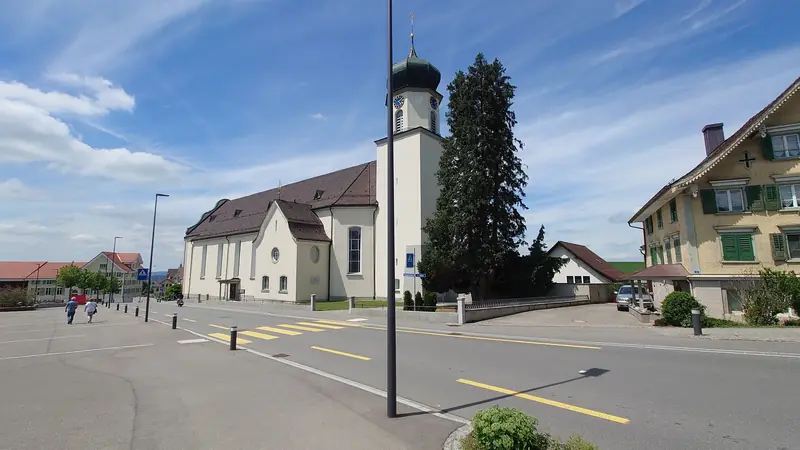 Die weisse Kirche St. Otmar mit Zwiebelturm im Dorfzentrum von Andwil.